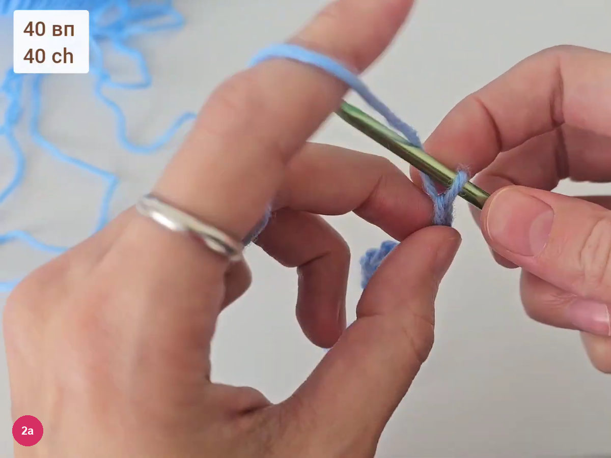 Blue yarn chain being worked on a hook held between both hands, with the note 40 ch at top left