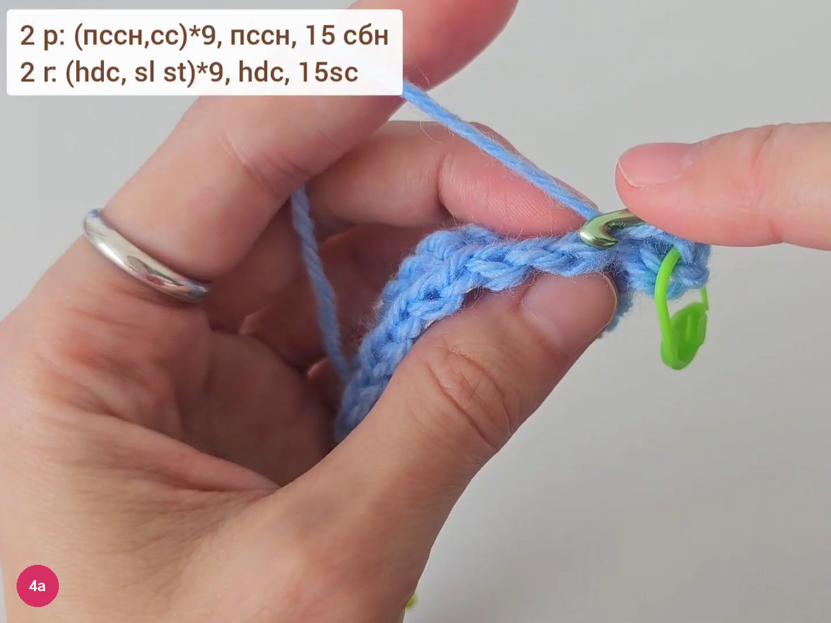 Hook entering the back loop of the previous row beside a green stitch marker, with the row 2 formula on screen
