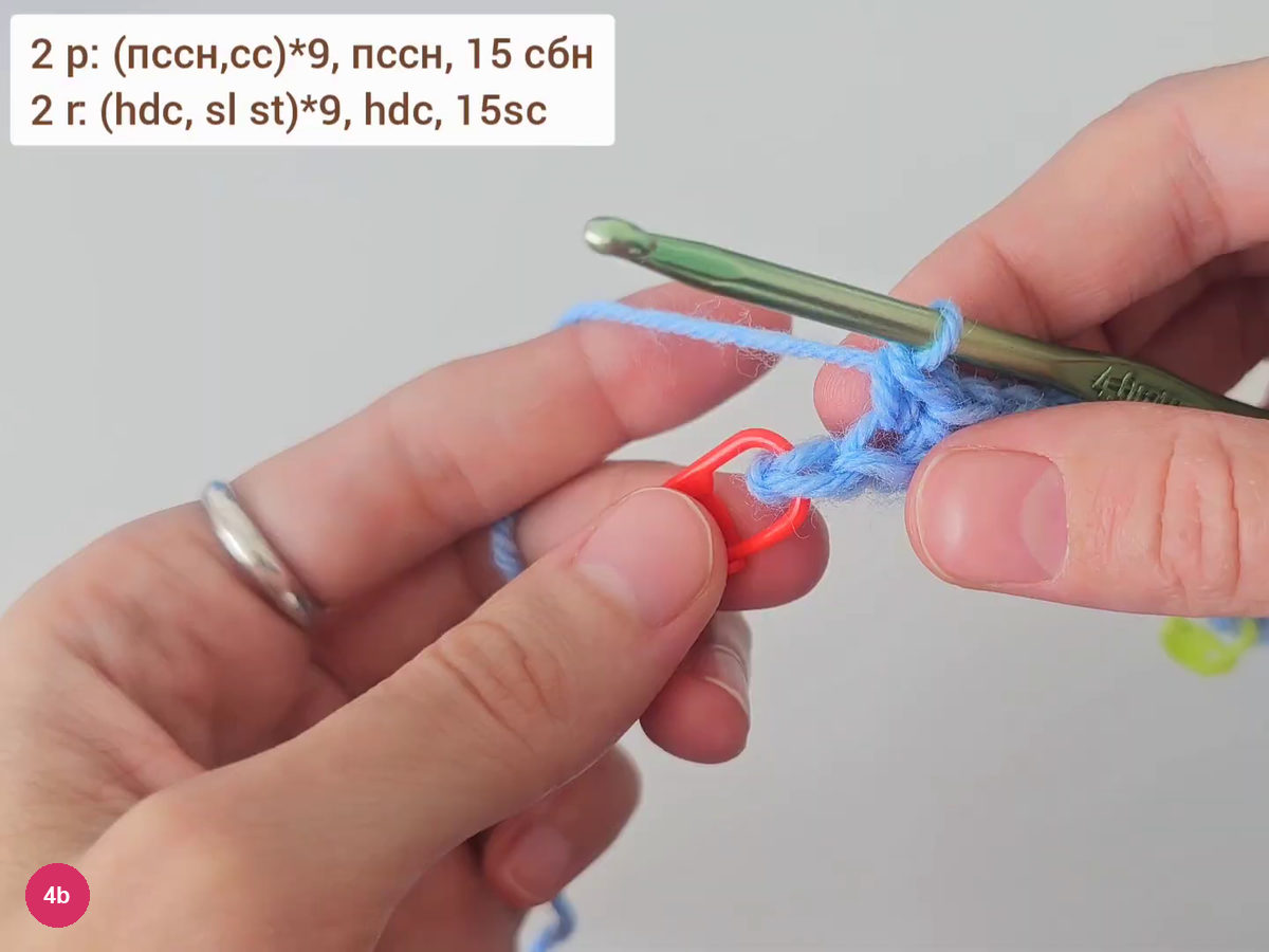Hook inserted at the end of a row beside a red stitch marker, with the row 2 formula on screen