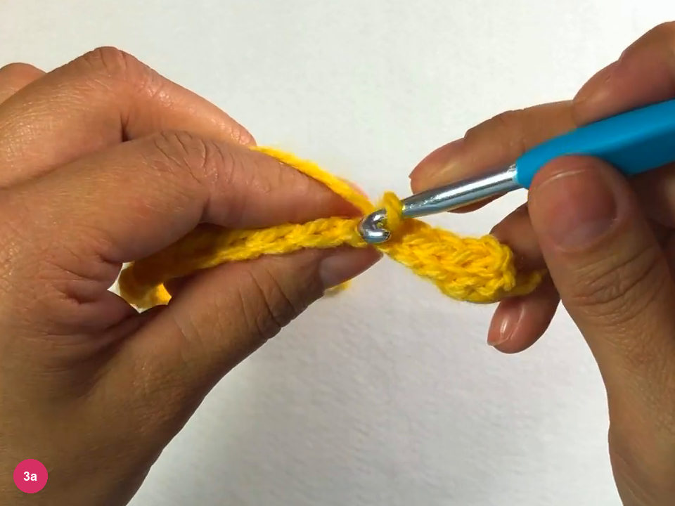 Hook working a back-loop slip stitch at the start of the second row, with the first row held in the left hand