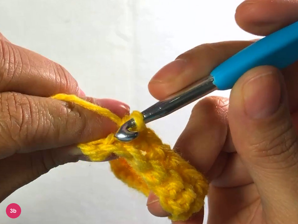 Hook at the end of the second row with the last stitch being worked, fabric held by the left hand