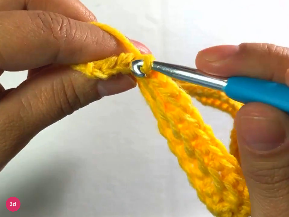 Hook making slip stitches at the end of the third row, with the loops held between the fingers