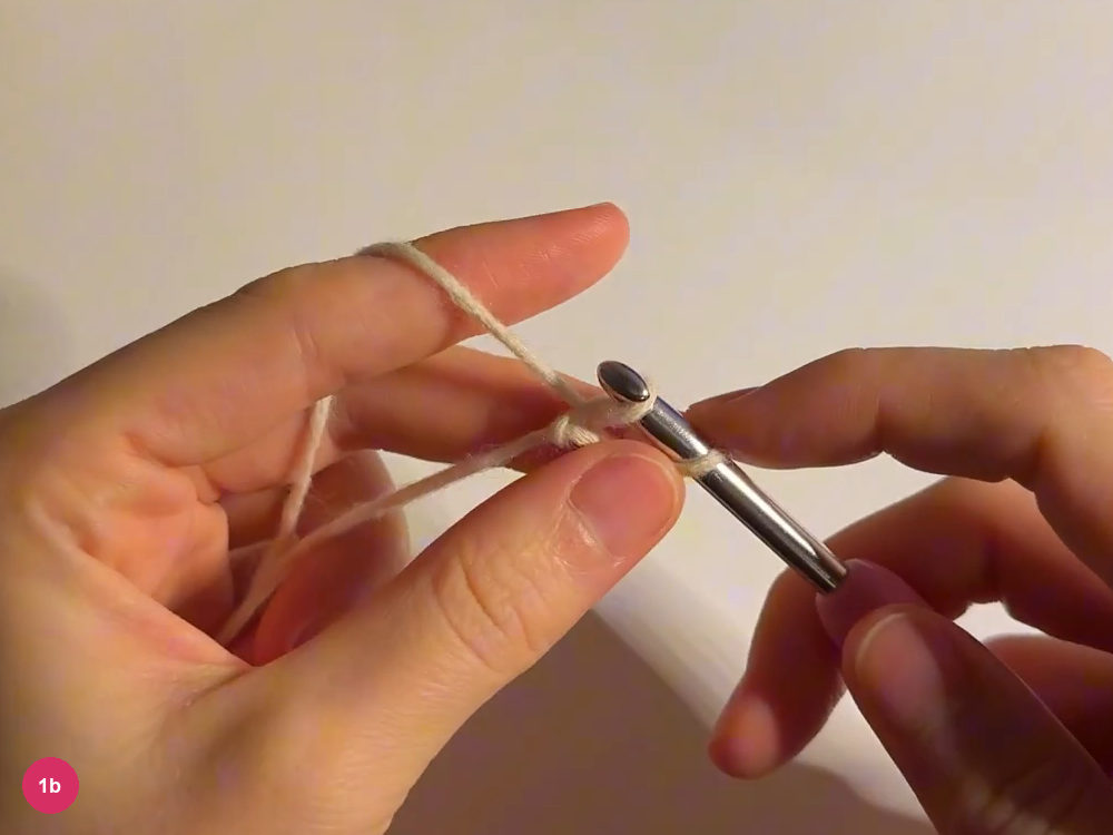 Hook entering the small cream foundation beside the left thumb