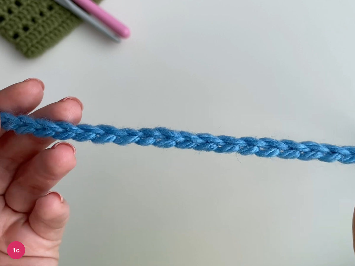 Long blue foundation chain held horizontally over the pale table
