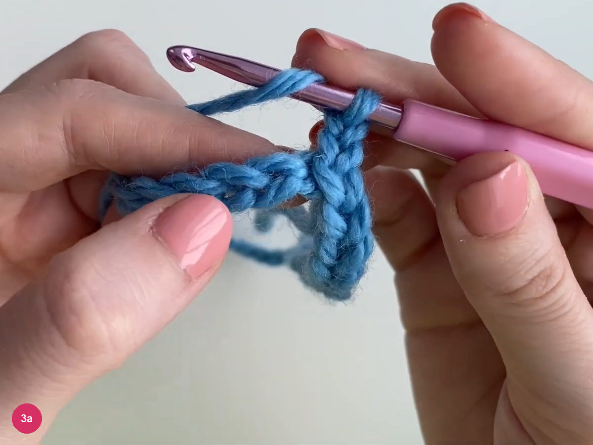 Blue yarn over the purple hook above the foundation chain