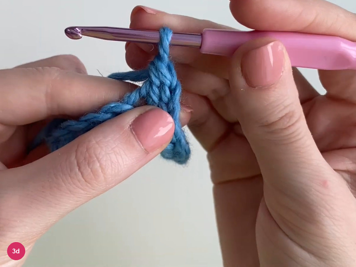 Completed blue double crochet beside the starting chain with one active loop on the hook