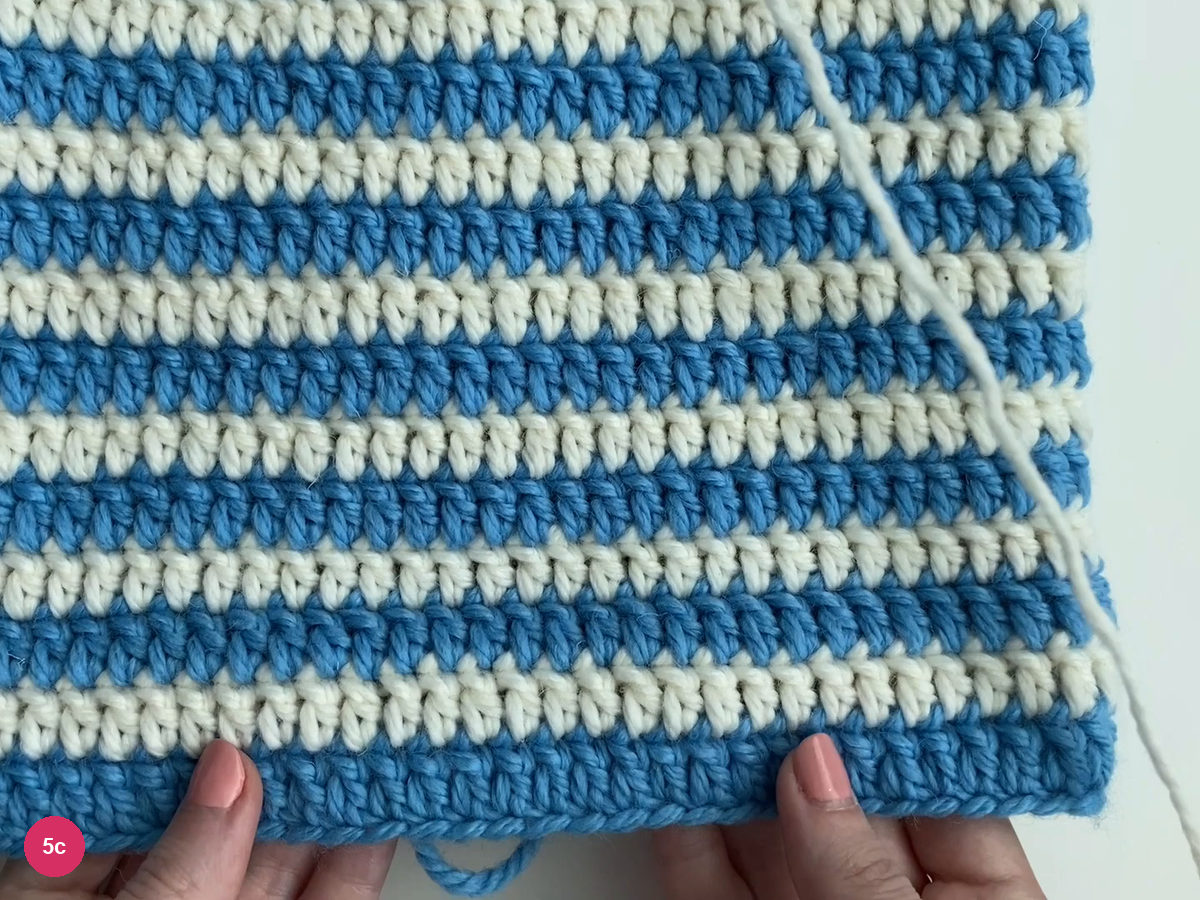 Alternating blue and white horizontal rounds across the body of the hat
