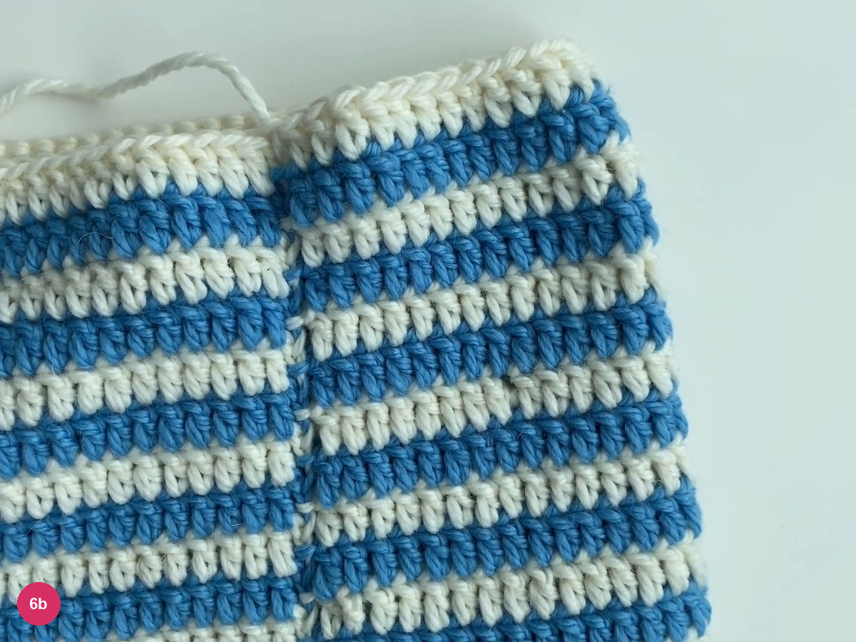 Finished striped tube with loose white yarn at its open top edge
