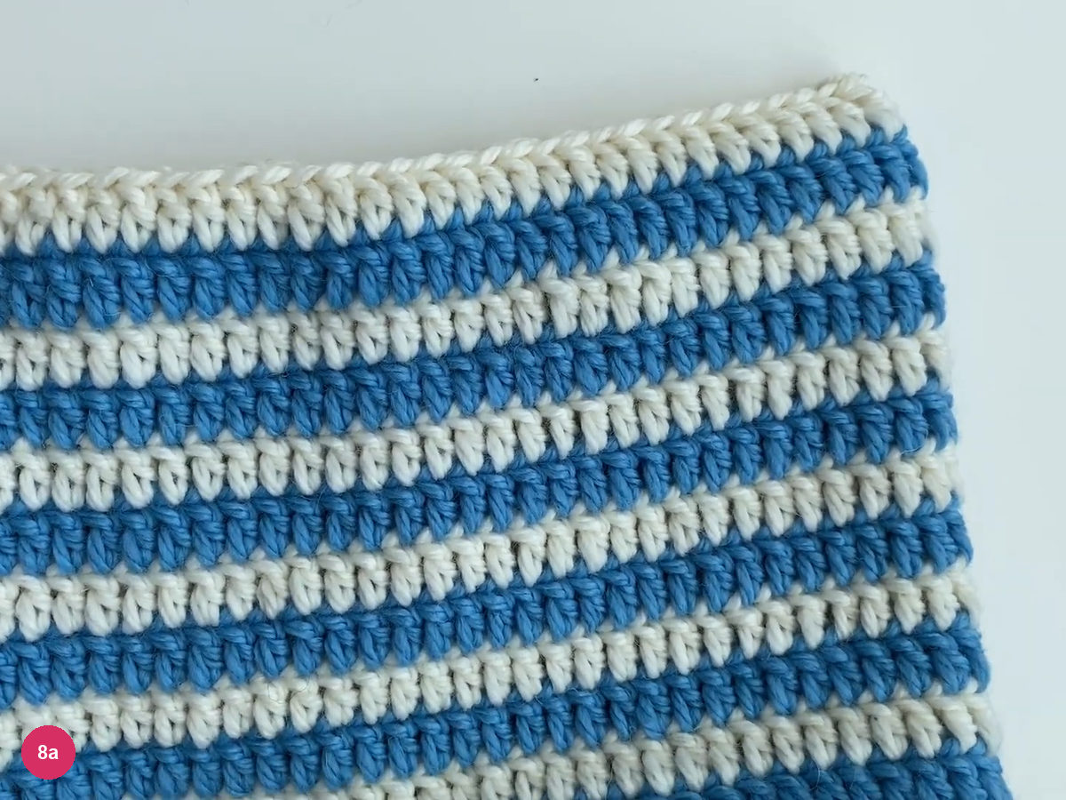 Closed straight white top seam above the blue-and-white hat body