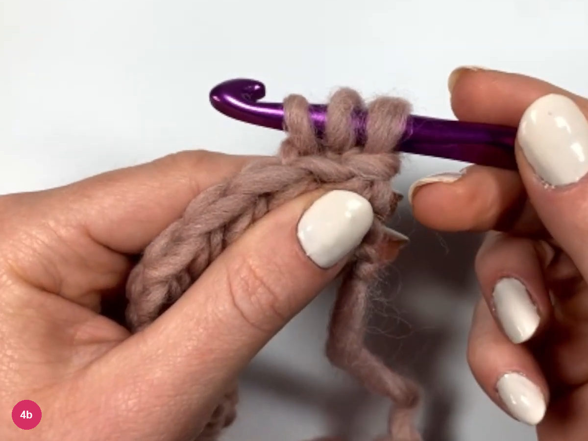 Three loops on the hook over the first stitch of row 2, with the chain strand hanging below
