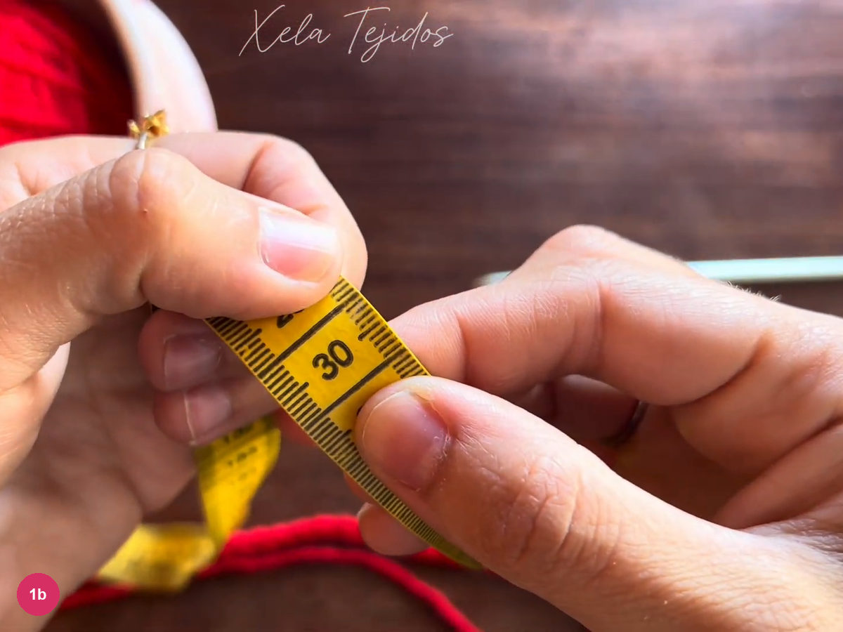 The 30 cm mark on a yellow measuring tape held above the red chain