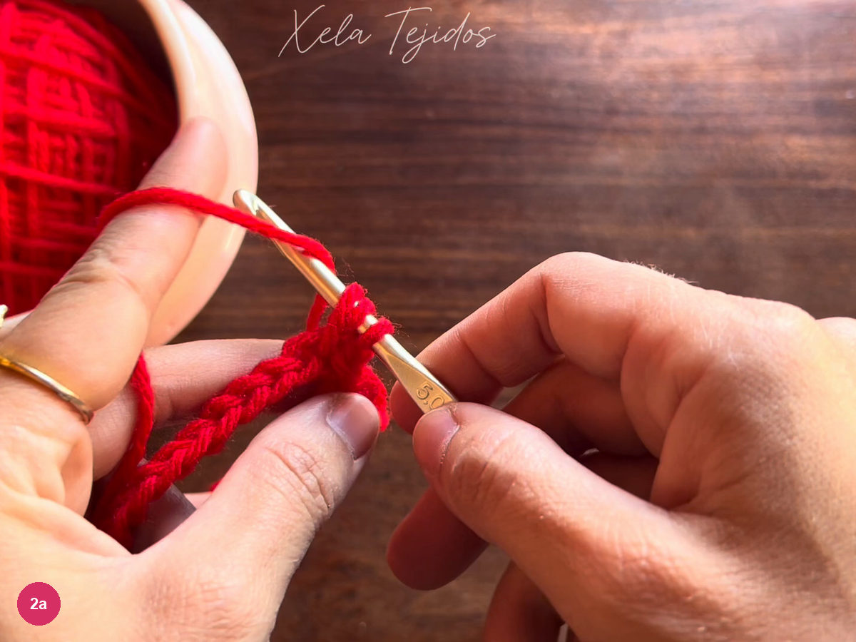 Three red loops on the metal hook during half double crochet
