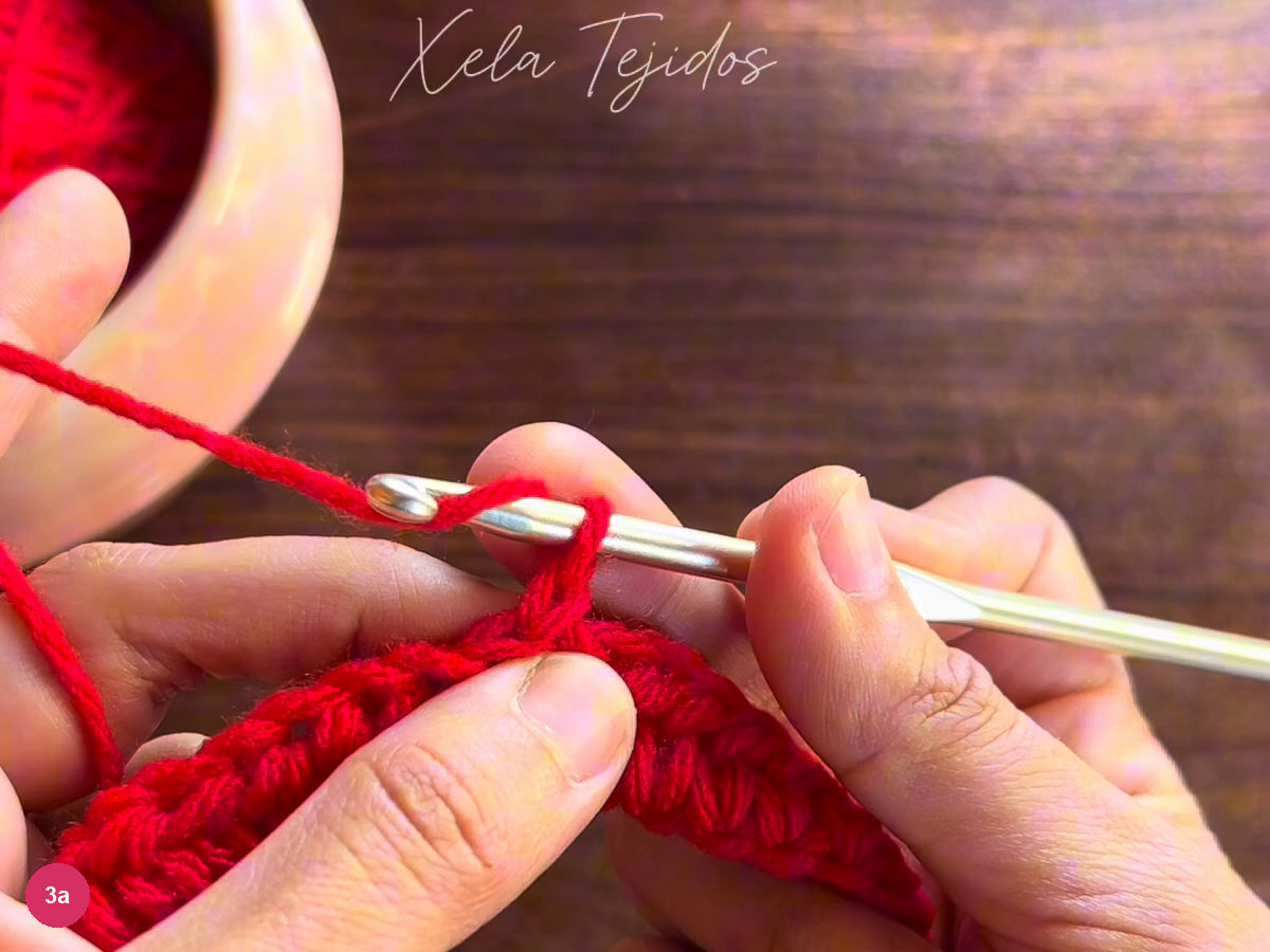 The turned red body row beneath the metal crochet hook