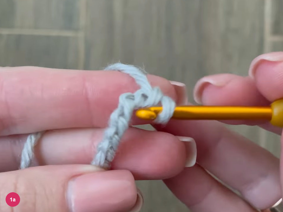 Light grey chain looped over a finger with the gold hook through the last loop