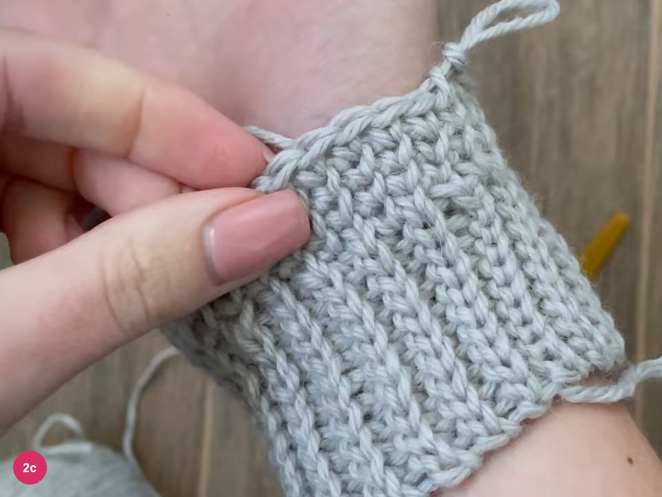Ribbed cuff with a plain single crochet edge held on a wrist