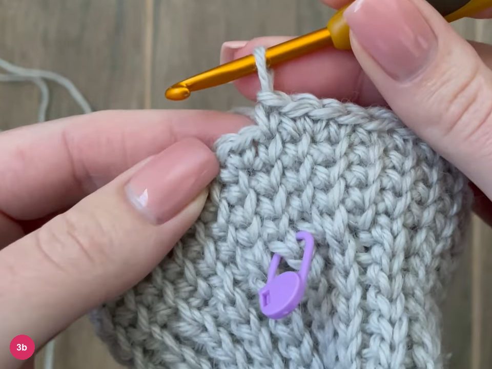 Hook at the top of the hand section with the purple marker below it in the single crochet fabric