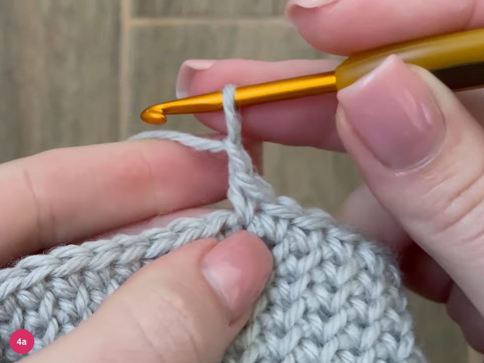 Hook with a short chain bridging from the edge of the fabric after the gusset stitches were skipped
