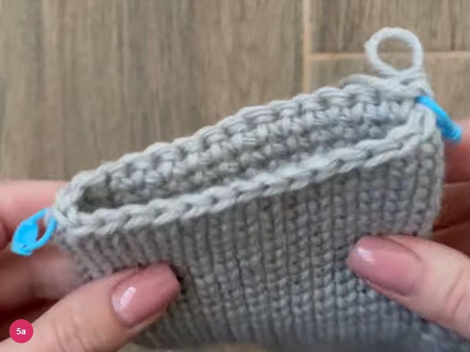 Flattened hand section with a blue stitch marker at each side edge