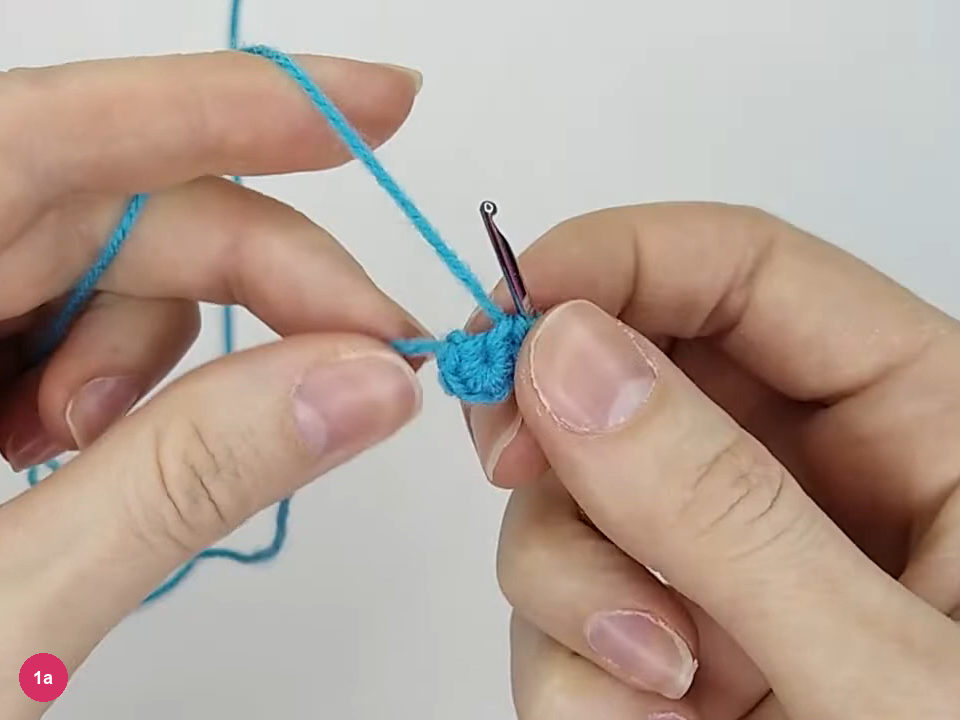 Small turquoise magic-ring disk held beside the hook