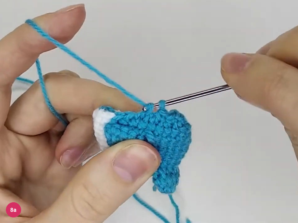 Two turquoise loops on the hook while completing an invisible decrease