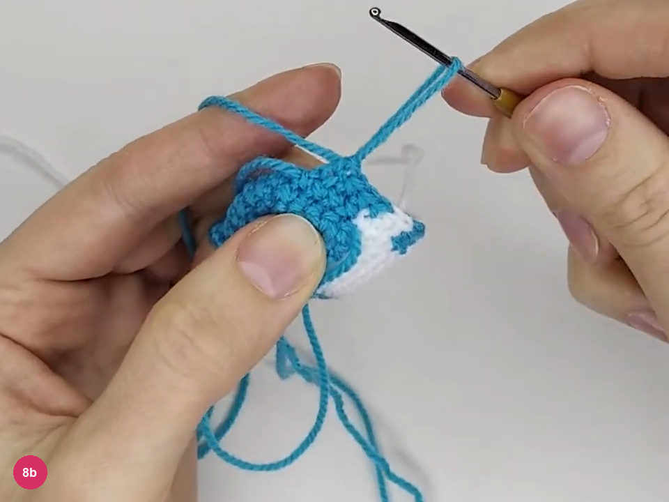 Turquoise working loop drawn above the narrowed body after completing the color-work decrease round
