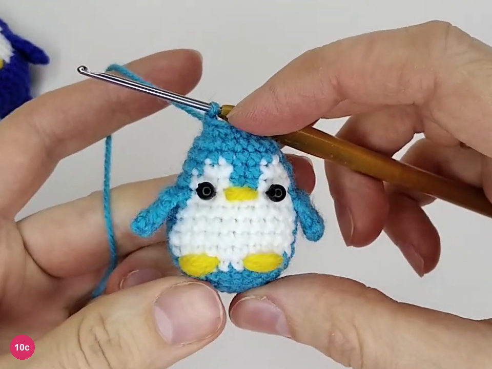 Finished face with black sewn bead eyes and yellow embroidered beak
