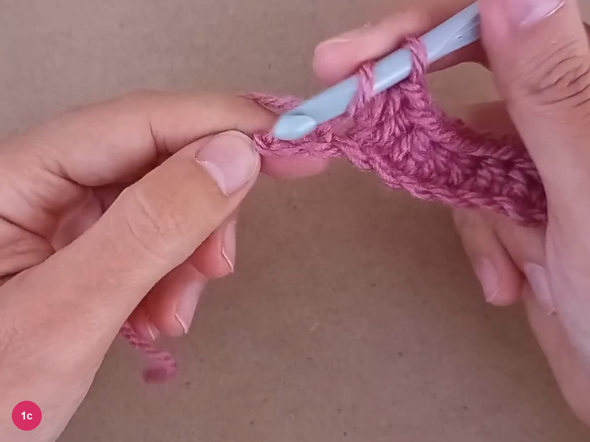 Last foundation stitches held beside the hook at the end of the rose strip