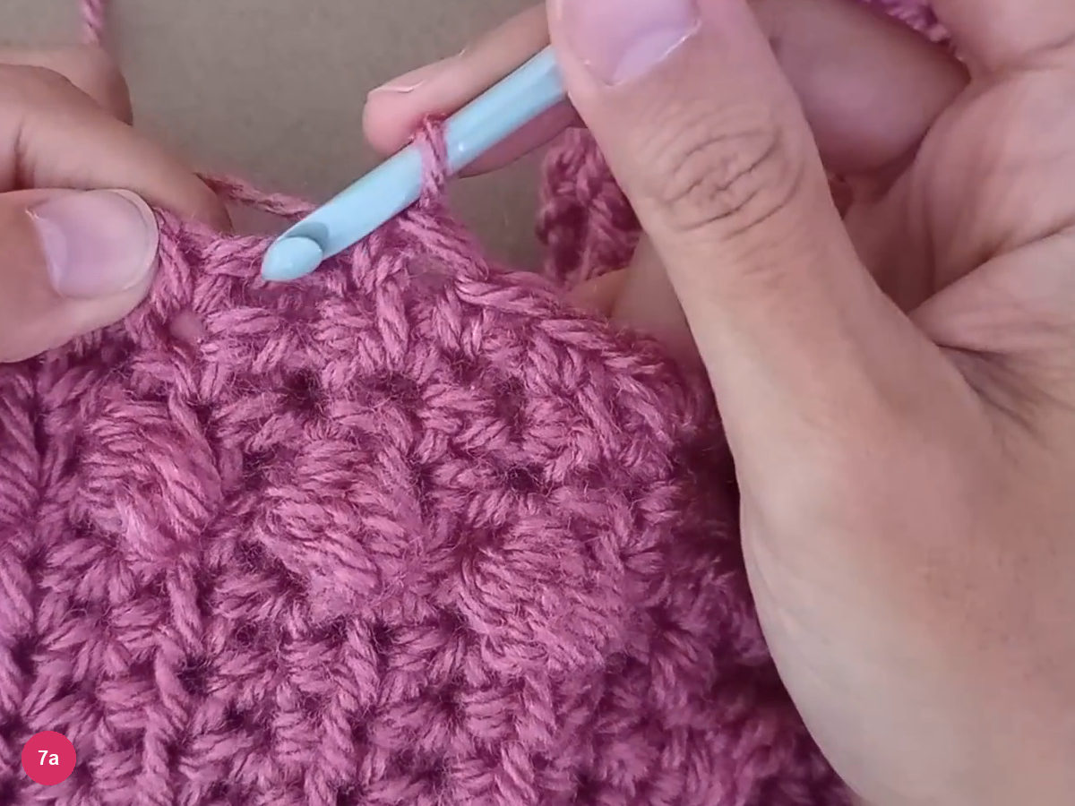 Hook working small stitches into the row ends along the neckline