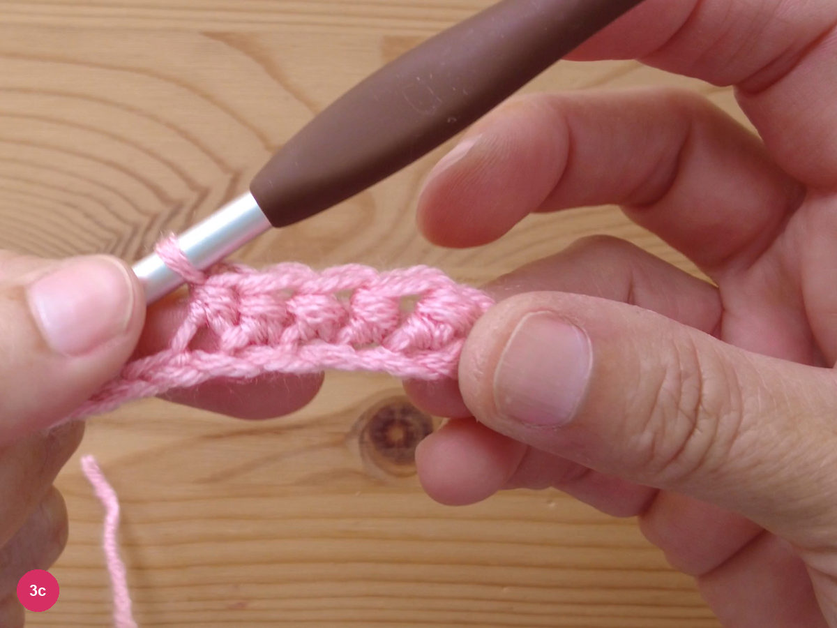 A short band of finished half double crochet stitches worked along the foundation chain, hook at the left end