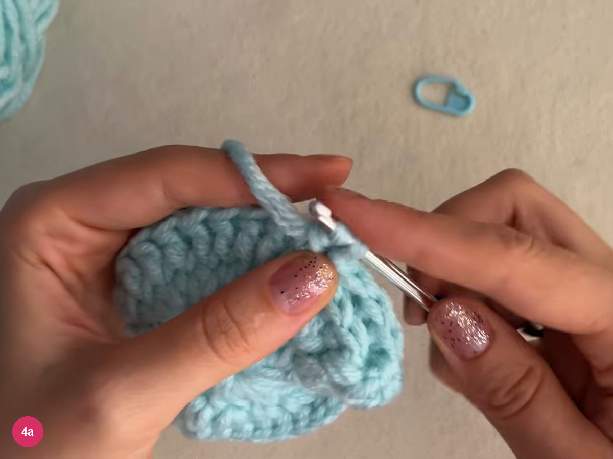 Cupped mint piece held in both hands with the hook at its upper edge as a new round begins