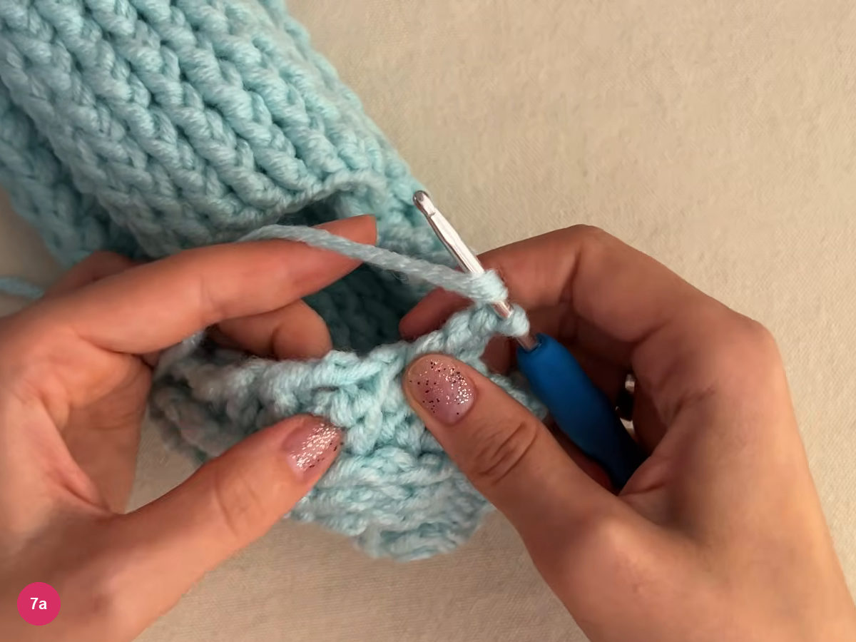 Yarn joined at the edge of the heel opening with the hook and a chain at the top edge, ribbed fabric behind