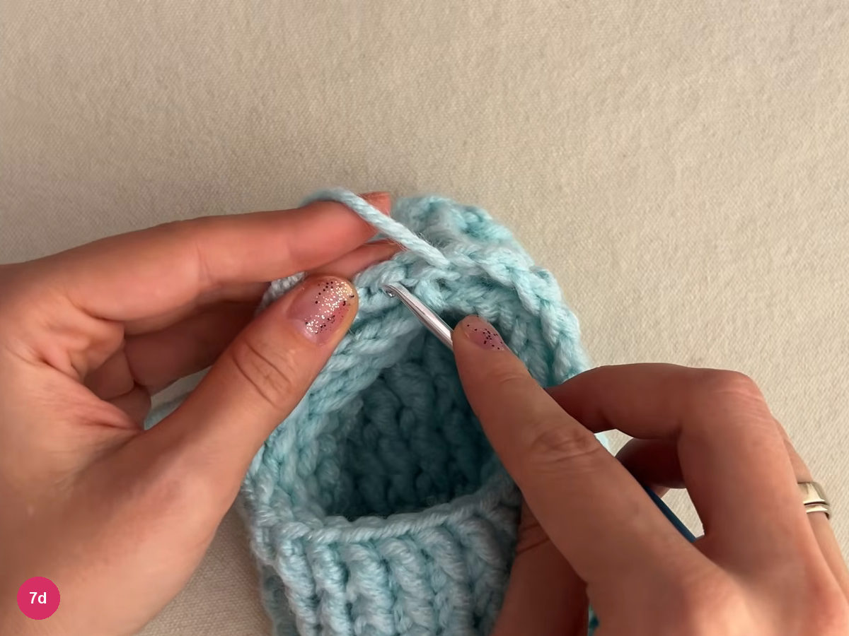Slipper opening from above with the hook placed in the top edge and the yarn over the left finger