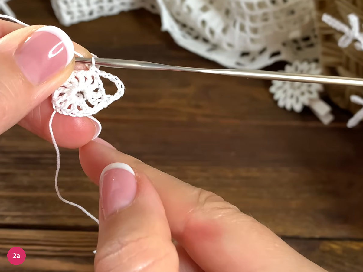 A long white chain arch bridges alternate spaces around the small crochet center