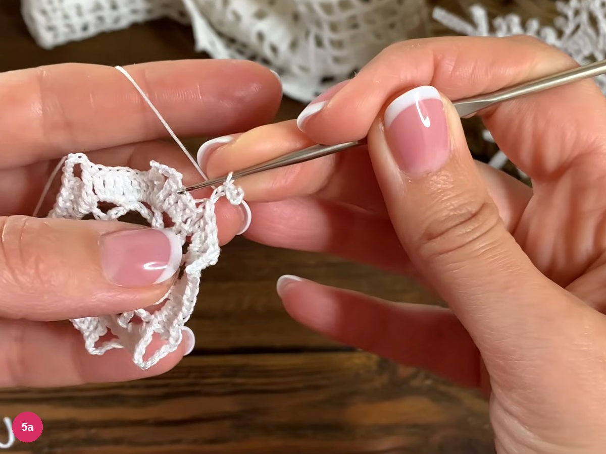 A small chain picot sits at the edge of the white lace framework