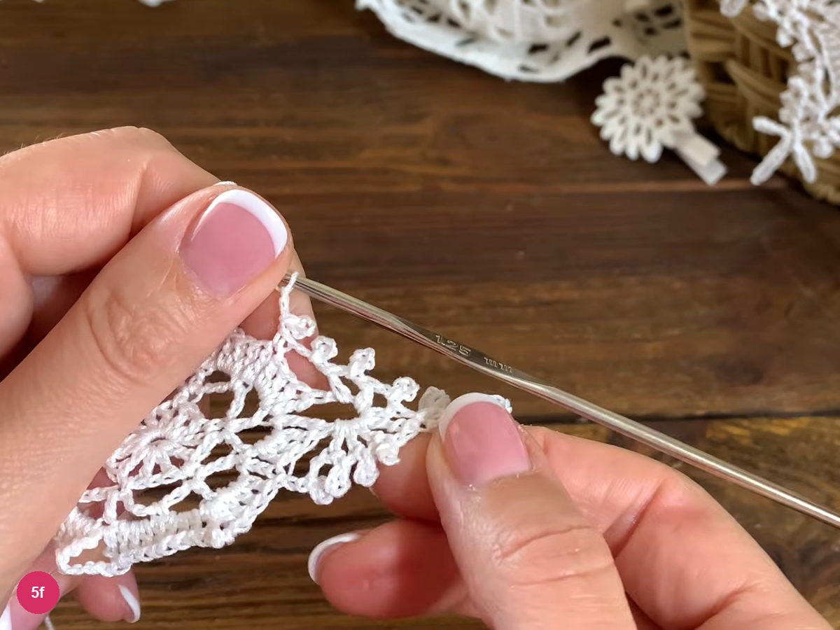 A small valley picot joins the branch to the middle of the connecting stitch band