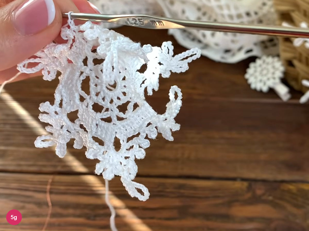 Joined, unblocked six-point lace edge held below the hook