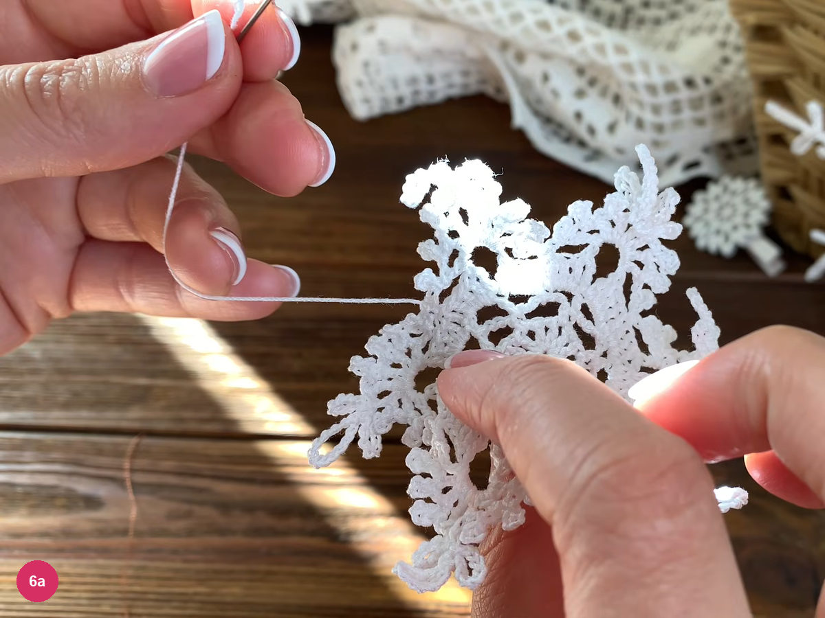 Finishing thread drawn out from the reverse of the white lace