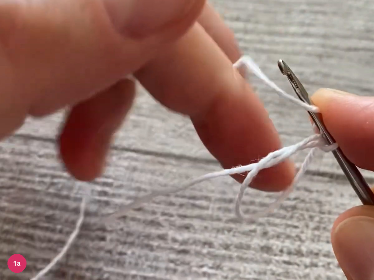 An open adjustable yarn ring hangs below the hook