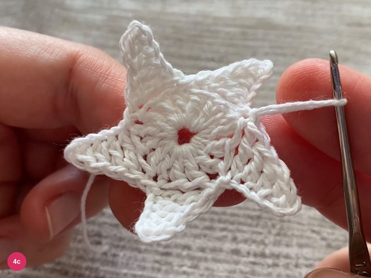 Five-point white star held open with the hook at the final join