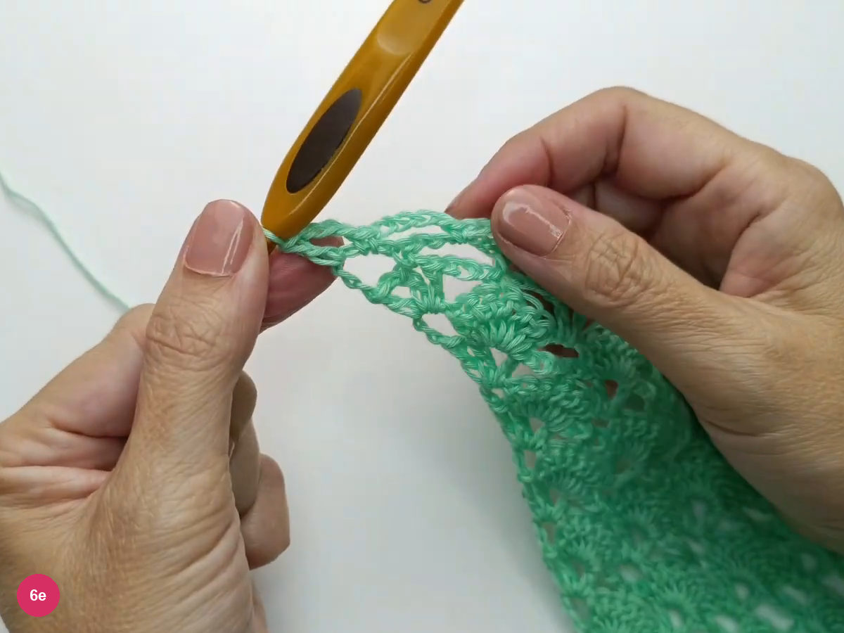 A single crochet, chain-three and double crochet shape the mesh edge.