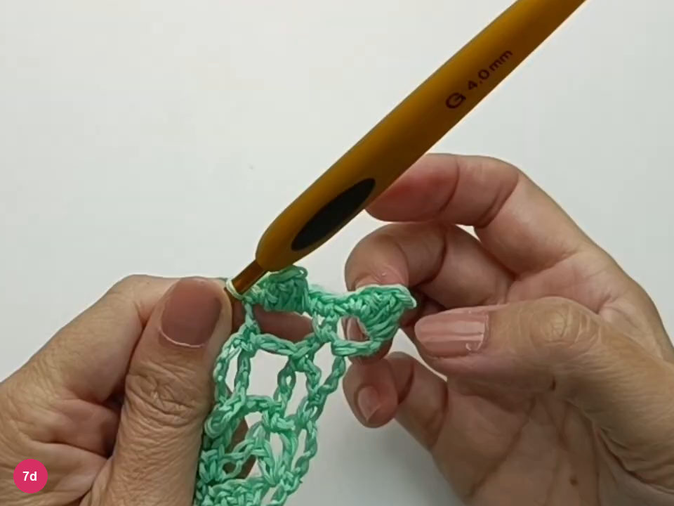 Neighboring crocheted bobbles sit on separate mesh arches.